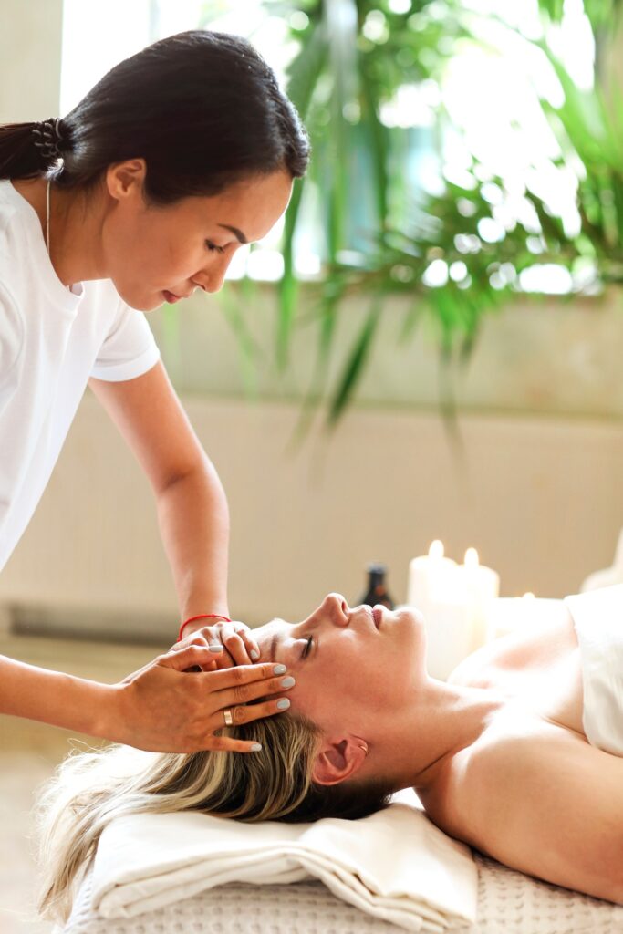 Therapist giving facial massage in spa